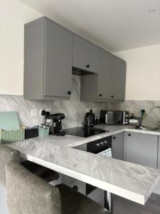 a kitchen with white cabinets and a counter top at Hillview Cabin in Oban