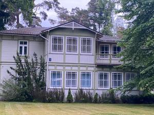a large white house with a balcony on top of it at Baltic Beach Villa I in Jūrmala