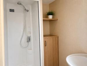a bathroom with a shower and a sink at Beachside 3 Bed Caravan with Deck & Outside Seating Mablethorpe in Mablethorpe +13 photos