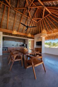 a dining room with a wooden table and chairs at Punta Arena Surf Suites in Puerto Escondido
