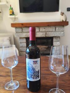 a bottle of wine sitting between two wine glasses at Mirador de Cerler in Cerler