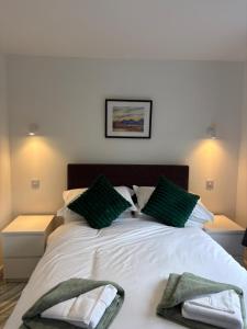 a bedroom with a bed with green pillows on it at Hillview Cabin in Oban