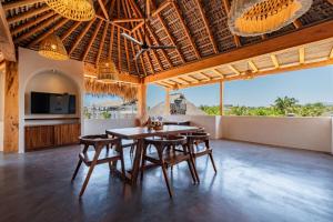 a dining room with a table and chairs at Punta Arena Surf Suites in Puerto Escondido