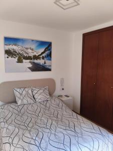 a bedroom with a bed and a wooden cabinet at Mirador de Cerler in Cerler