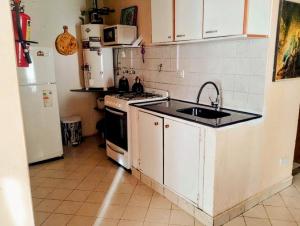 a kitchen with a stove and a sink and a refrigerator at Alojamiento FARAH in Caviahue