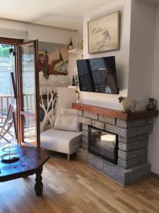 a living room with a fireplace with a tv above it at Mirador de Cerler in Cerler