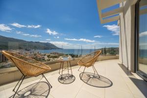 two chairs and a table on a balcony with a view at Boreti Panorama Residence in Boreti +3 photos