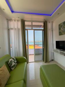 a living room with a green couch and a view of the ocean at Sea View Big Lanche in Praia Baixo