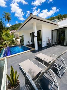 a villa with a swimming pool and lounge chairs at Villa Ravenala in Chaweng in Ban Ko Khwan