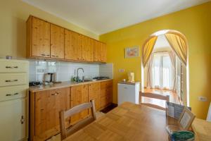 a kitchen with wooden cabinets and a wooden table with a wooden table at Hiša pri poetu in Šempeter pri Gorici +16 photos