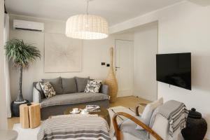 a living room with a couch and a tv at Luxurious Bohemian Residence with Pool in Tivat