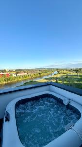 a hot tub on a balcony with a view at River View Penthouse & Jacuzzi in Reghin