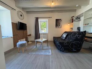 a bedroom with a bed and a tv in a room at Escapade en Auvergne - centre historique - 3 personnes in Olliergues