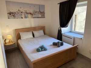 a bedroom with a bed with two shoes on it at Escapade en Auvergne - centre historique - 3 personnes in Olliergues
