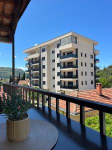 a balcony with a table and a building at Apartmani MM Trebinje in Trebinje