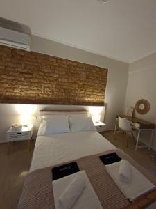 a bedroom with a large bed with a brick wall at Elia Studios 2 in Nydri