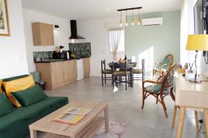 a living room with a green couch and a table at Les Blés d'Or - Parking privé, Terrasse, Clim, Netflix, Au Calme in Hem-Lenglet +15 photos