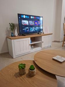 a living room with a tv and a table at Elia Studios 2 in Nydri