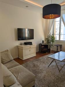 a living room with a couch and a flat screen tv at AC-Free Parking - Contemporary 4 Bedroom Villa Apartment in Cannes +5 photos