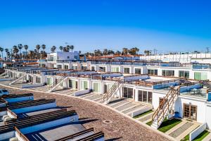 a row of white buildings with blue roofs at Dog-friendly home 3 rows to beach with rooftop deck, pool, & kitchen in Rosarito