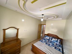 a bedroom with a bed and a mirror at Catrass Oualidia Apartments in Oualidia