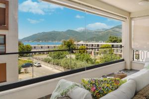 a living room with a couch and a large window at Luxurious Bohemian Residence with Pool in Tivat
