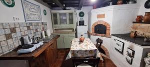 a small kitchen with a table and a stove at Age Gone By Guesthouse in Kemenesmihályfa
