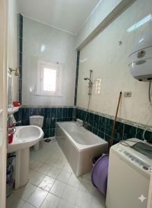 a bathroom with a tub and a sink and a bath tub at Dina Mansour's vacation home 54 A upper in Dawwār ‘Abd Allāh