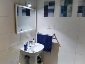 a white bathroom with a sink and a mirror at River House Lodge in Luxor +8 photos