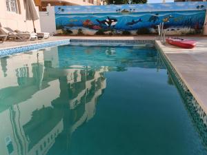a swimming pool with a painting on the wall at River House Lodge in Luxor