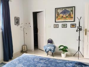 a bedroom with a blue bed and a plant at River House Lodge in Luxor