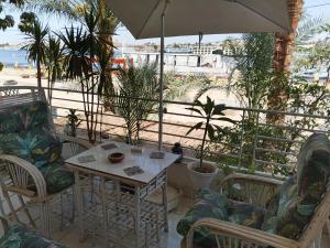 a patio with a table and chairs and an umbrella at River House Lodge in Luxor