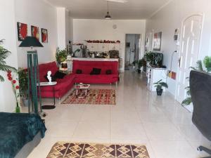 a living room with a red couch and a table at River House Lodge in Luxor