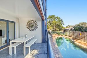 a balcony with a table and a swimming pool at Poolside 2-Bed Apartment Near Coolangatta in Gold Coast