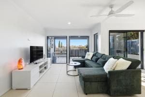 a living room with a couch and a tv at Poolside 2-Bed Apartment Near Coolangatta in Gold Coast
