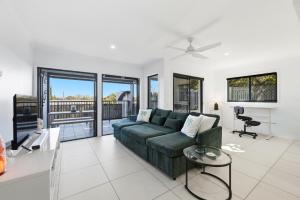 a living room with a green couch and a table at Poolside 2-Bed Apartment Near Coolangatta in Gold Coast