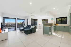 a kitchen and living room with a couch and a table at Poolside 2-Bed Apartment Near Coolangatta in Gold Coast +16 photos