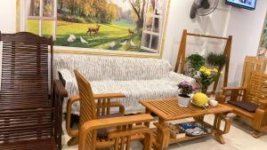 a living room with a couch and a table at T - Bona Homestay in Xã Thang Tam
