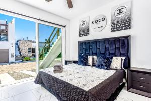 a bedroom with a bed and a large window at Dog-friendly home 3 rows to beach with rooftop deck, pool, hot tub, & kitchen in Rosarito
