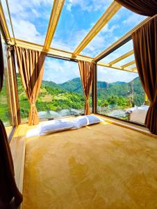 a bed in a room with a large window at Glass House Merisi 2 in Merisi +12 photos