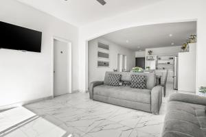 a living room with a couch and a tv in it at Dog-Friendly Home with Heated Pool, Hot Tub, Partial Ocean Views & Balcony in Rosarito