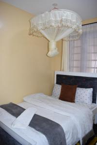 a bedroom with a bed with white sheets and a window at Unique place Studio Thika in Thika