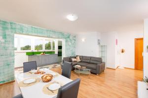 a living room with a table and a couch at Apartman Izi Green s pogledom na more in Kornić