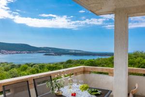 a table on a balcony with a view of the water at Apartman Izi Green s pogledom na more in Kornić