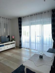 a living room with a tv and a couch at Apartment Cherry s pogledom na more in Dinjiška