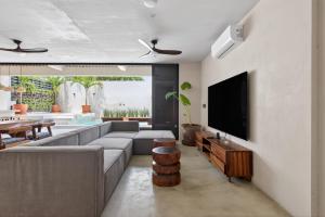 a living room with a couch and a flat screen tv at La Barra Resorts Luxury Villas in Paso Hondo