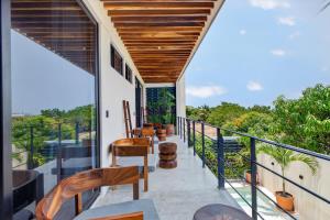 a balcony with chairs and tables on a building at La Barra Resorts Luxury Villas in Paso Hondo