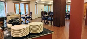 a stack of plates on a counter in a restaurant at The Pamir Hotel in Nubra +61 photos