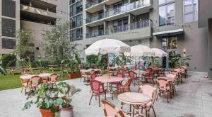 an outdoor patio with tables and chairs and umbrellas at Miami Downtown Bayside Balcony Studio in Miami