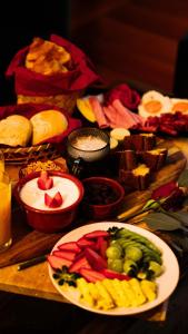 a table topped with plates of food with fruits and vegetables at Quinta dos Lobos Boutique Hotel - Nature Experience in Sintra